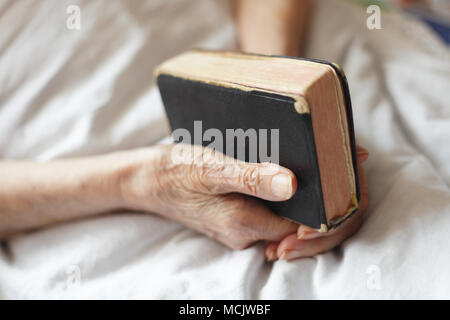Hände von einer älteren Frau auf Zuckerrohr. Senior liegen in einem Bett. Stockfoto