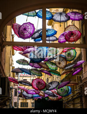 Sonnenschirme hängen an den Drähten in einer Straße Passage. Schöner Stop in der Stadt Stockfoto