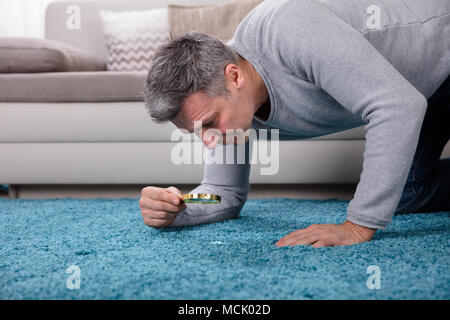 Seitenansicht eines reifer Mann im blauen Teppich durch die Lupe Stockfoto