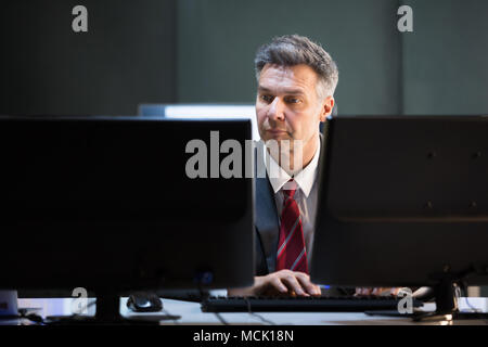 Reifen Geschäftsmann mehrere Computer im Büro Schreibtisch Stockfoto