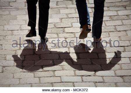 Schatten von zwei Menschen gingen Hand in Hand an einem schönen Tag, eine alte Straße in Salzburg, Österreich. Credit: reallifephotos/Alamy Stockfoto