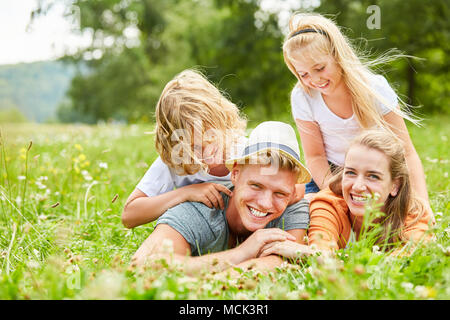 Kinder haben Spaß beim Spielen mit ihren Eltern auf einer Sommerwiese Stockfoto