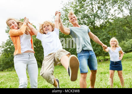 Junge spielt umwerfend mit seinen Eltern und seiner Schwester im Garten Stockfoto