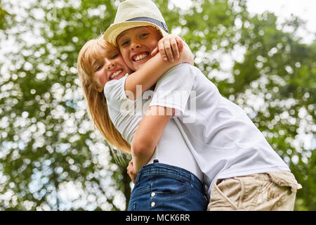 Bruder und Schwester umarmen einander glücklich während Reunion in der Landschaft Stockfoto