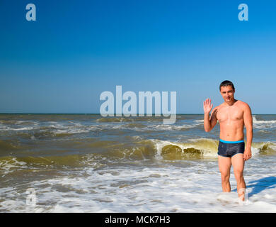 Sport Mann kommt aus dem Meerwasser. Baden im Meer. Ein Mann ist das Schwimmen unter den Wellen des Meeres. Stockfoto