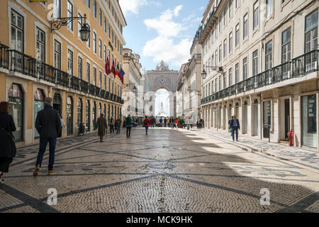 Menschen zu Fuß entlang der Rua Augusta, mit dem Arco da Vitoria im Hintergrund in Lissabon, Portugal. Stockfoto