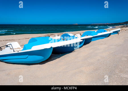 Reihe von weißen und blauen Tretboote auf dem sardischen Strand von Badesi Stockfoto