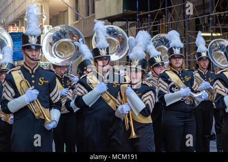 Aline Band, New York City, St. Patrick's Day Parade, 2018. Blaue Uniformen, mit goldenen Schärpen. Weißen Federn. Hörner, Trompeten, Tuben. Stockfoto