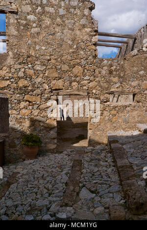 Die Wand eines alten Hauses in den Strahlen der hellen Sonne. Stockfoto