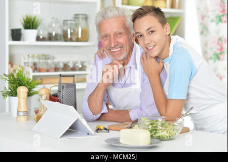 Älterer Mann mit Enkel Vorbereitung Abendessen in der Küche Stockfoto