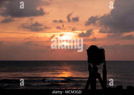 Silhouette einer Digital-SLR-Kamera schießen einen dramatischen Moment Sonnenuntergang am Strand. Stockfoto