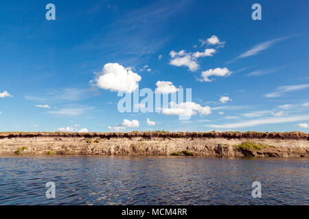Panoramablick auf das riverbank mit Reflexionen von flauschigen weissen Wolken und blauer Himmel auf Welligkeit Wasseroberfläche Stockfoto