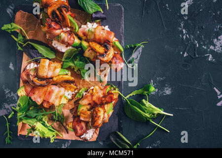 Avocado Sandwich mit hausgemachten Ciabatta Brot mit frischen in Scheiben geschnittenen Avocado gekochte und gebratene Speck und Pilzen. Kopieren Sie Platz für Ihren Text. Stockfoto