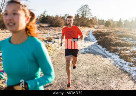 Mann und Frau joggen in Discovery Park, Seattle, Washington State, USA Stockfoto