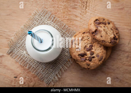 Mit Milch und Chocolate Chip Cookies auf dunklem Hintergrund Flasche. Ansicht von oben. Stockfoto