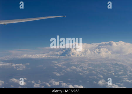 Flugzeugflügel fliegen in einem schönen blauen Himmel mit Wolken Stockfoto