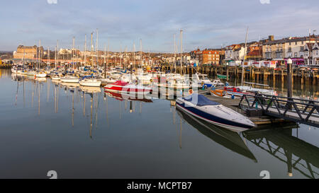 Spiegelungen im Wasser am Hafen von Scarborough, North Yorkshire, UK. Touristische Yachten und Sportboote in Scarborough Marina. Stockfoto