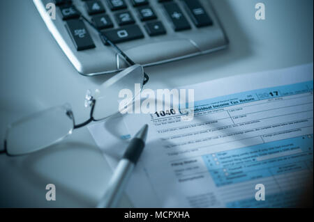 1040 US-Steuer Formular mit Taschenrechner, Stift und Gläser Stockfoto