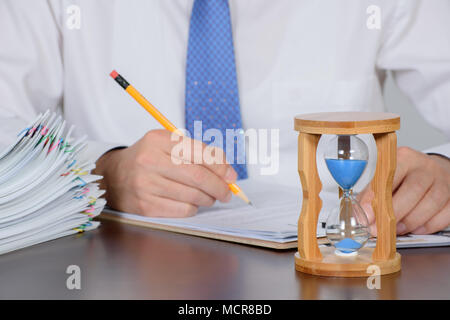 Ein Geschäftsmann organisiert eine große Anzahl von Dokumenten. Stockfoto