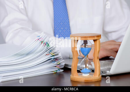 Ein Geschäftsmann organisiert eine große Anzahl von Dokumenten. Stockfoto