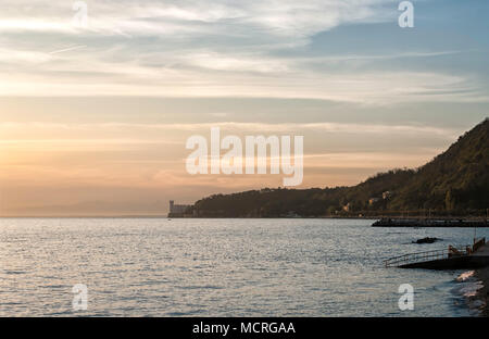 Blick auf den romantischen Golf von Triest und das wunderschöne Schloss Miramare bei Sonnenuntergang. Schloss Miramare ist ein aus dem 19. Jahrhundert Schloss erbaut für die österreichischen Erzherzog Stockfoto