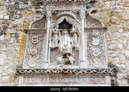 Bas Relief der König von Ungarn Matthias in voller Rüstung sitzt mit seinen Füßen auf einem Löwen. Engel halten eine Krone auf sein Haupt. Auf beiden Seiten Wappen. Stockfoto