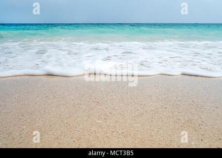 Soft Blue Ocean Wave am Sandstrand. Hintergrund. weißen Sand am Strand mit türkisblauem Wasser. Eine exotische Insel im Indischen Ozean Stockfoto