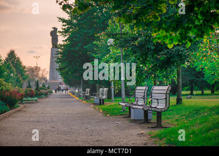 Leere Sitze in Parkbänke. Schönen romantischen Sommerabend. Candle light Pfad zum Meer. Menschen Wandern und Entspannen. Stockfoto