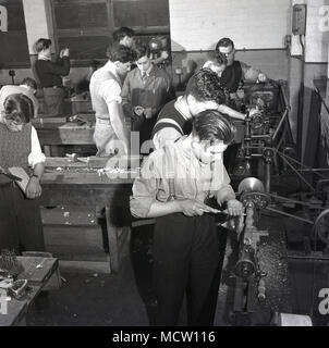 Historisches Bild, 1950er Jahre, einer Gruppe von männlichen engineering Lehrlinge mit Hilfe von Werkzeugmaschinen und "hands-on", praktische Erfahrung in der industriellen Workshop, England, UK. In Großbritannien gab es eine bedeutende Ausweitung der Technischen Hochschulen und der lehrlingsausbildung mehr junge Menschen in wichtigen Industriebereichen wie Maschinenbau und Fertigung zu fördern. Stockfoto