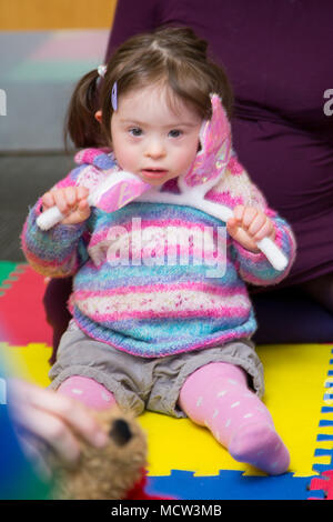 Ein kleines Kind mit Downs-Syndrom in der Spielgruppe, Großbritannien Stockfoto