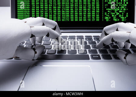 Roboterhand Arbeiten am Laptop mit binären Code auf dem Bildschirm Stockfoto