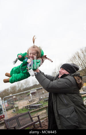 Ein Vater schwingt seine Tochter in der Luft, Großbritannien Stockfoto