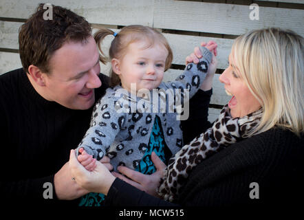 Mama und Papa mit ihrer 17 Monate alten Tochter, außerhalb, Großbritannien Stockfoto