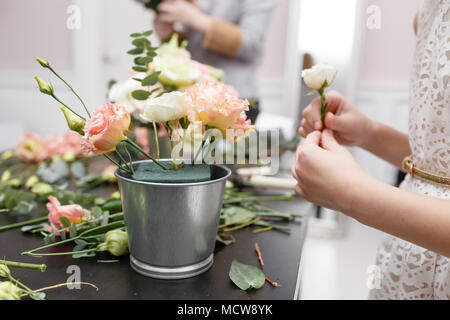 Master Class auf dem Bilden der Blumensträuße für Kinder. Spring Bouquet in Metall dekorativen Blumentopf. Lernen Blumen arrangieren, wunderschöne Blumensträuße mit ihren eigenen Händen. Stockfoto