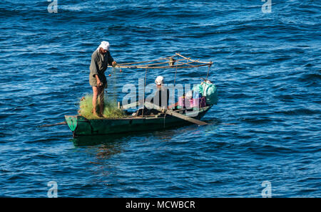 Zwei ägyptische einheimische Männer in traditioneller Kleidung und Turbane in kleinen Ruderboot mit Fischernetze, Morgenlicht, Nil, Ägypten, Afrika Stockfoto