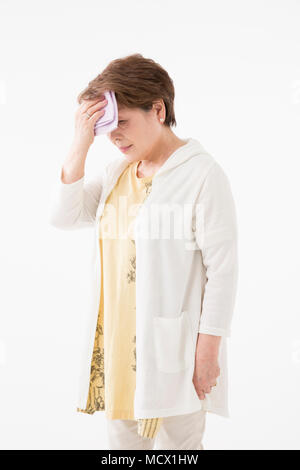 Ältere Frau wischt Schweiß Stockfoto