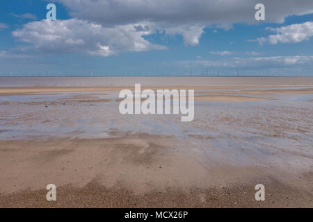 Einsame Strand in Skegness, UK, mit Windkraftanlagen in der Ferne am Meer Stockfoto