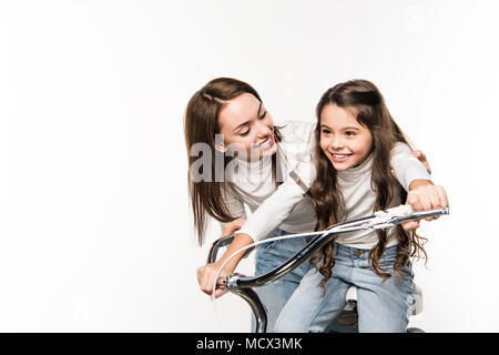 Mutter, Tochter mit dem Fahrrad isoliert auf weißem Stockfoto