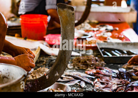 Fischer schneiden von Fisch auf einem ständigen Blade boti in der indischen Fischmarkt in Kolkata Stockfoto