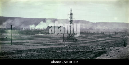 Hochspannungs-Linie, die durch das Feld, auf dem Hintergrund der Hügel im Rauch. Schwarz-weiß Foto im Retro-stil (Ukraine, Zolochiv) Stockfoto