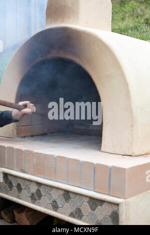 Feuer Vorbereitung für Pizza backen im Ofen im Freien Stockfoto