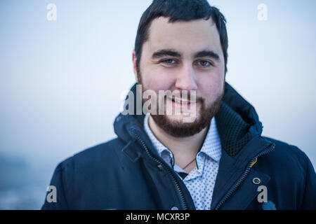 Portrait einer jungen brutalen sarkastischen Mann an der Kamera auf der Suche Stockfoto