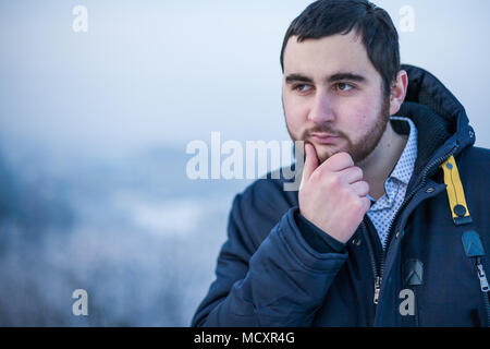 Portrait einer jungen nachdenklich nachdenklich Mann hand Halten am Kinn Stockfoto