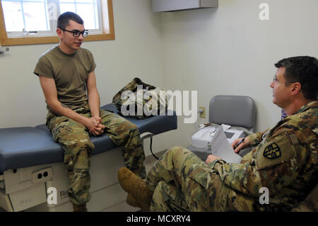 Spc. Jesse White, einem Fachmann in der 7409Th Truppe Medizinische Klinik zugeordnet, demonstriert den Prozess ein Soldat wird durch beim Besuch der TMC gehen. Weiß visits Maj. Jonathan Hutchings, eine Familie Praxis Arzt simulieren, um die Soldaten mit ihren Provider haben wird. ARMEDCOM Soldaten zu 7212Th medizinische Unterstützung und 7409Th Truppe Medizinische Klinik zugeordnet unterstützt medizinische Soldat Bereitschaft Verarbeitung und Truppe Medizinische Klinik Operationen während ihrer Ausbildung am Fort McCoy, Wisconsin am März 1-15, 2018. Die erfolgreiche proof-of-concept-Programm ist Implementierung Stockfoto