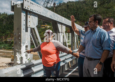 Utuado, Puerto Rico. März 13, 2018 -- Überlebende der Río Abajo Gemeinschaft, feiert mit dem Gouverneur von Puerto Rico, Ricardo Rosselló, und andere überlebende bei der Einweihung der neuen Brücke. Heute, dank der Anstrengungen der örtlichen, Landes- und Bundesbehörden, die Gemeinschaft hat zur Normalität zurückgekehrt. Stockfoto