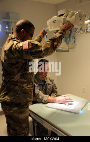 Staff Sgt. Perry Johnson, eine Radiologie Specialist 7417th Truppe Medizinische Klinik zugeordnet, prüft sein Patient, Sgt. Hector Santiago, ein petroleumversorgung Specialist zu 941St Quartermaster Co., 1. Mission unterstützt den Befehl zugeordnet, für Handverletzungen beim Training in Fort Knox, Kentucky. ARMEDCOM Soldaten zu 7231St medizinische Unterstützung und 7417Th Truppe Medizinische Klinik zugeordnet unterstützt medizinische Soldat Bereitschaft Verarbeitung und Truppe Medizinische Klinik Operationen während ihrer Ausbildung in Fort Knox, Kentucky auf März 1-15, 2018. Die erfolgreiche "Proof-of-Concept"-Programm wird von mehreren umgesetzt Stockfoto