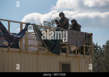 Dutch Marines mit 32 Raid-Geschwader, klar eine Dachterrasse bei einer militärischen Operationen in urbanem Gelände Training übung in Camp Lejeune, N.C., 23. März 2018. Marines mit 2. Strafverfolgung Bataillon, militärische Gebrauchshund Platoon, mit niederländischen Marines als Vermögenswert für Improvised Explosive Devices, Waffe caches Suche integriert, und versteckte Kammern. Marines mit 2 LE Bataillon jährlich Schulungen mit der niederländischen Marines Interoperabilität zu erhöhen. Stockfoto