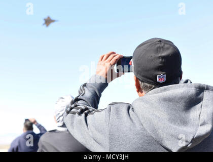 Eine specator Filme ein US Air Force F-22 Raptor Fighter jet Durchführung Manöver in den Himmel im Los Angeles County Air Show in Lancaster, Kalifornien, 22. März 2018 statt. Das Team wird 21 Plätze für 25 Leistung für die 2018 Saison besuchen. Stockfoto