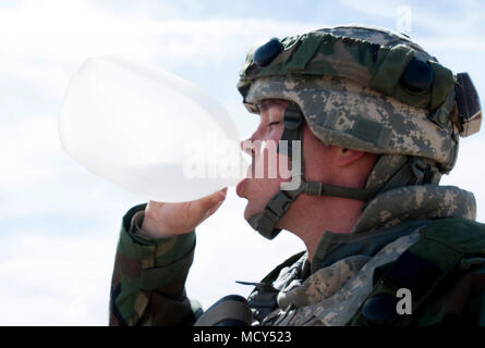 Ein Soldat der 256 Combat Support Hospital zugewiesen, in Twinsburg, Ohio mit Sitz, Getränke Wasser aus einer Gallone - große Kanne während Combat Support Training Übung 18-03 am Fort McCoy, Wisonsin am 26. März 2018. Die 256 CSH eine Zielsetzung Wettbewerb umgesetzt, betitelt Dandy Camp, zu Lehren ermutigen Soldaten ihre gesamten Kohlenhydraten während der Übung zu überwachen. Das übergeordnete Ziel der Dandy Camp ist Soldaten über gesundes Essen zu erziehen und Soldaten fördern und treffen Ziele für sich. Stockfoto