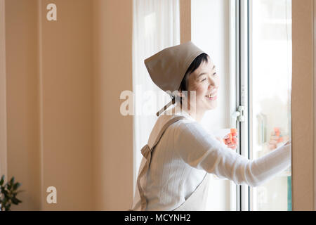 Ältere Frau Reinigung Fenster Stockfoto
